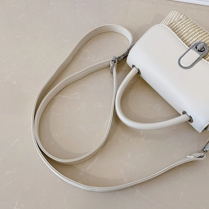 Macro view of cream PU leather and straw woven texture with silver metal oval twist lock