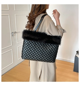 Detail view of black quilted tote bag with faux fur trim and diamond pattern stitching