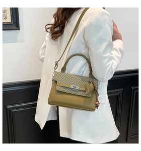 Detail of olive green handbag featuring woven texture and silver twist-lock closure