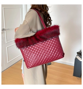 Detail of burgundy quilted tote bag with faux fur trim shown in home setting