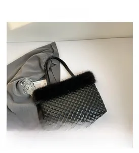 Detail of black quilted tote bag featuring elegant faux fur trim and diamond stitch texture