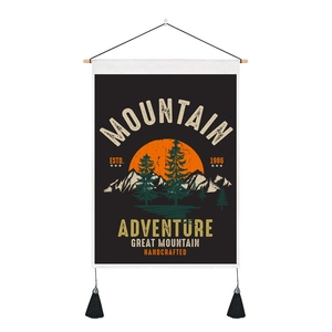 Detail of vintage outdoor adventure wall art with mountain sunset print and black tassels