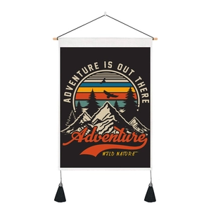 Close-up of retro adventure tapestry with wood pole, black tassels and mountain landscape