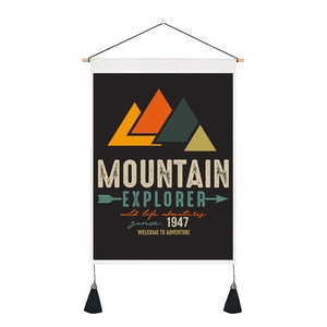 Detail of minimalist mountain explorer wall hanging with wood frame and black tassels