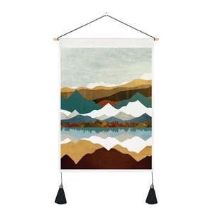 Close-up of Nordic tapestry with wooden rod, mountain print, and black fringe tassels