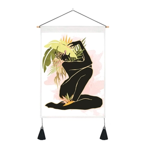 Detail of artistic wall tapestry with black silhouette and tropical leaves with tassels
