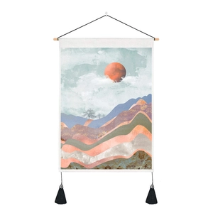 Detail of sunrise tapestry with wooden rod, black hanging rope, and corner tassels