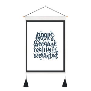Detail of canvas wall hanging with quote and wooden pole with black tassels decor