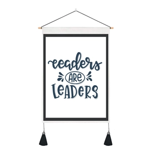 Detail of nordic fabric wall hanging with readers ARE LEADERS text and black tassels