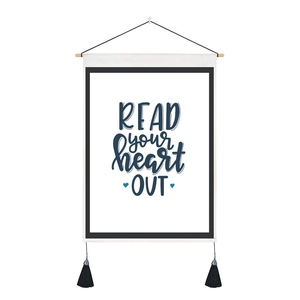 Detail of canvas hanging wall art with Read Your Heart Out typography and black tassels