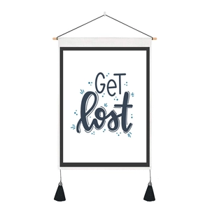 Close-up of a minimalist white tapestry featuring blue Get Lost lettering and black tassels