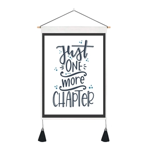 Detail of canvas wall hanging with JUST ONE MORE CHAPTER quote and wooden hanger