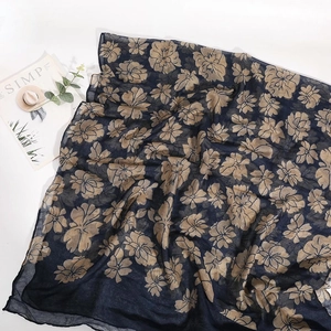 Detail of floral print scarf in navy blue and beige with a soft cotton-linen texture
