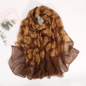Detail of soft brown floral scarf with yellow prints and elegant hemmed edges