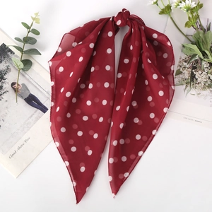 Red retro polka dot chiffon scarf tied in a bow with elegant floral background