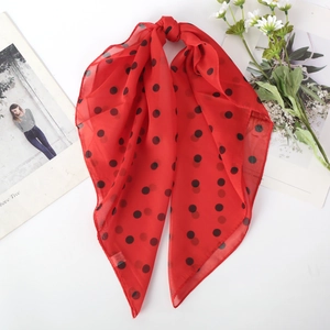 Detail of red polka dot chiffon scarf with soft drape and delicate floral decoration