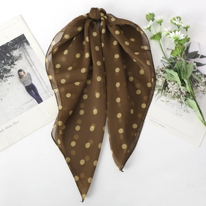 Detailed texture of brown polka dot chiffon scarf with soft drape and artistic layout