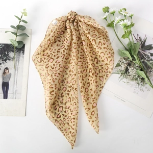Detailed close-up of leopard print silk scarf with fine edge stitching on chiffon fabric