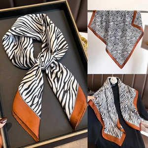 Détail d'un foulard en satin à motif zébré avec bordure caramel en plusieurs styles