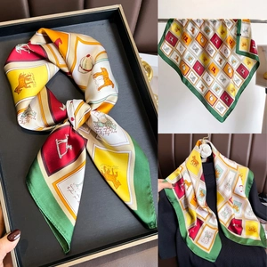 Détail macro du foulard en soie à imprimé équestre avec chevaux et étriers