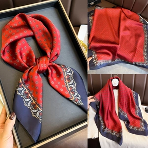Vue détaillée d'un foulard en soie rouge et bleu marine avec motifs paisley élégants