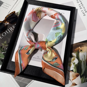 Silk scarf with lemon floral print and orange stripes, shown in an elegant lifestyle setting