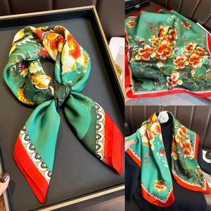 Vues détaillées d'un foulard en soie vert à motifs floraux et bordures rouges