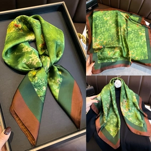 Détail d'un foulard en soie à fleurs vertes avec finition élégante de l'ourlet marron
