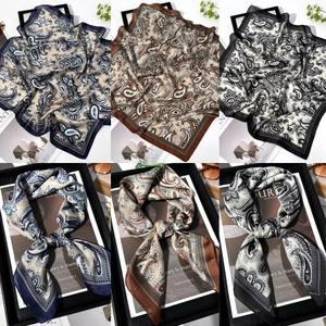 Detail of paisley print silk-feel scarves in navy, brown and black with geometric borders