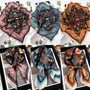 Three assorted silk scarves featuring intricate paisley patterns and vintage floral prints