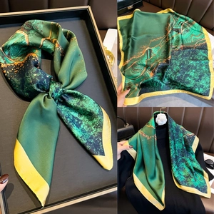 Vue détaillée d'un foulard en soie à imprimé marbre vert et bords jaunes élégants