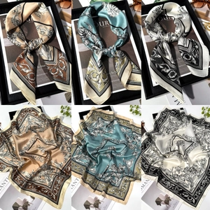 Detailed view of three vintage floral satin square scarves with elegant botanical prints