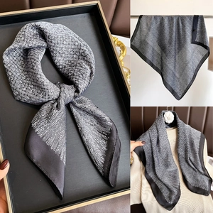 Détail d'un élégant foulard en soie imprimé noir et blanc noué avec style