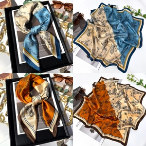Detail of vintage floral pattern silk-like square scarves in blue and orange colors