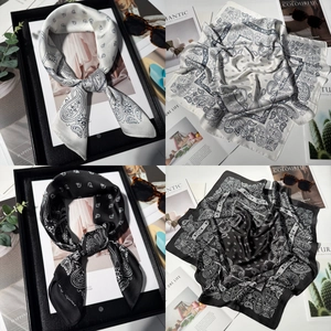 Detail of silk-feel square scarf with classic paisley print and elegant glossy texture