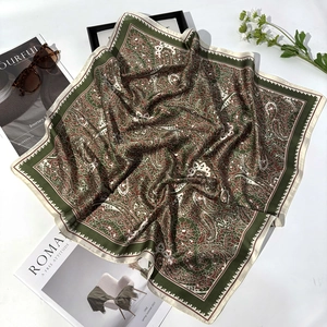 Elegant paisley silk scarf with green and brown patterns displayed with fashion accessories