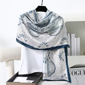 Detail of blue and white paisley print satin scarf draped over a casual white T-shirt