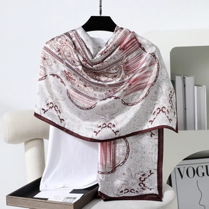 Detail of elegant paisley satin scarf with silky texture draped on a casual white top