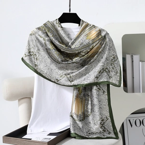 Detail of vintage paisley silk scarf with dark green border and intricate floral pattern