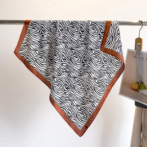 70cm zebra print silk square scarf with brown border hanging on a minimalist display