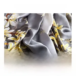 Macro shot of faux silk fabric featuring elegant magnolia print and smooth satin texture