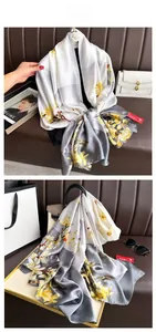 Detail view of the elegant magnolia flower and bird print on the satin silk scarf