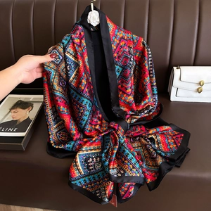 Gros plan d'un foulard en soie aux motifs géométriques vibrants et bordure noire