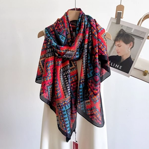 Détail d'un foulard en satin aux motifs géométriques ethniques et couleurs vives