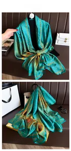 Macro detail of silk-like scarf featuring golden feather patterns and vintage heart borders