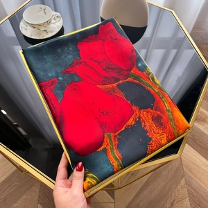 Detailed close-up of a faux silk scarf featuring large red rose prints on dark teal fabric