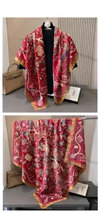 Detail of red vintage silk scarf with golden floral patterns and elegant drape effect