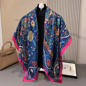Detail of floral silk square scarf featuring deep blue pattern and pink contrast edges