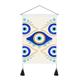Detail of Evil Eye wall tapestry featuring a wooden rod and black decorative tassels