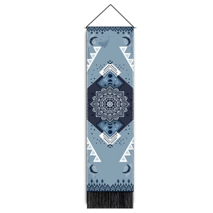 Detail of bohemian mandala tapestry with moon and star patterns and black fringe tassels